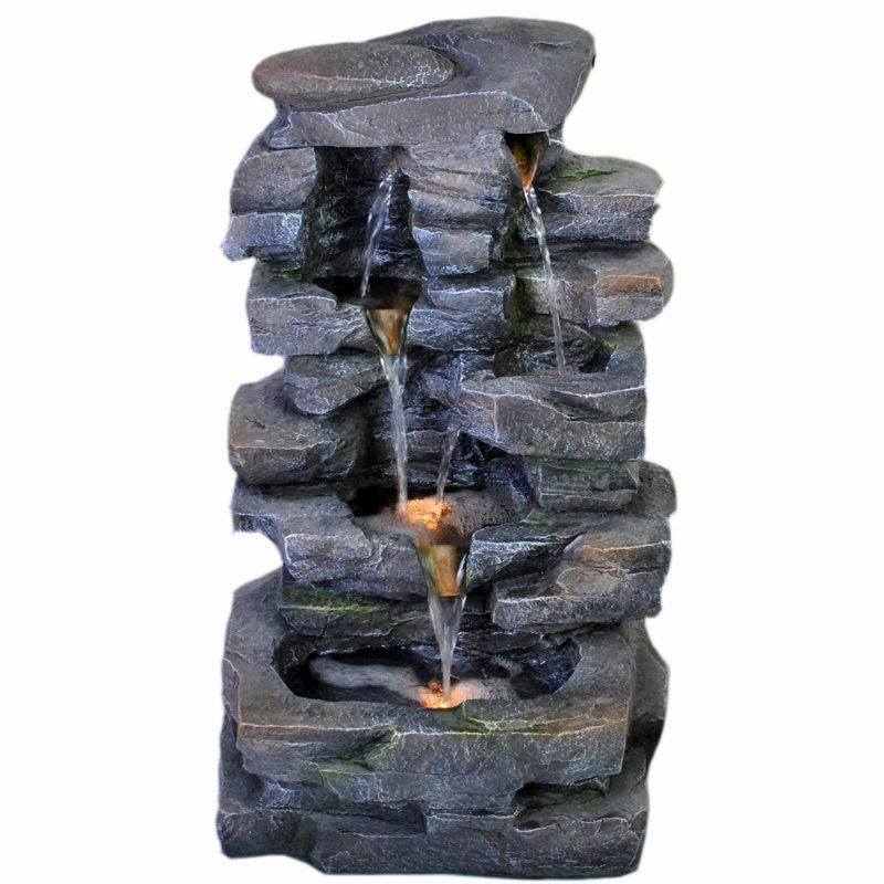 Gelaagde rotsformatie verlichte waterfontein